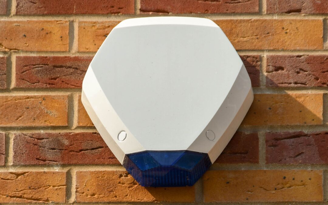 white external burglar alarm siren mounted on brick wall for home security