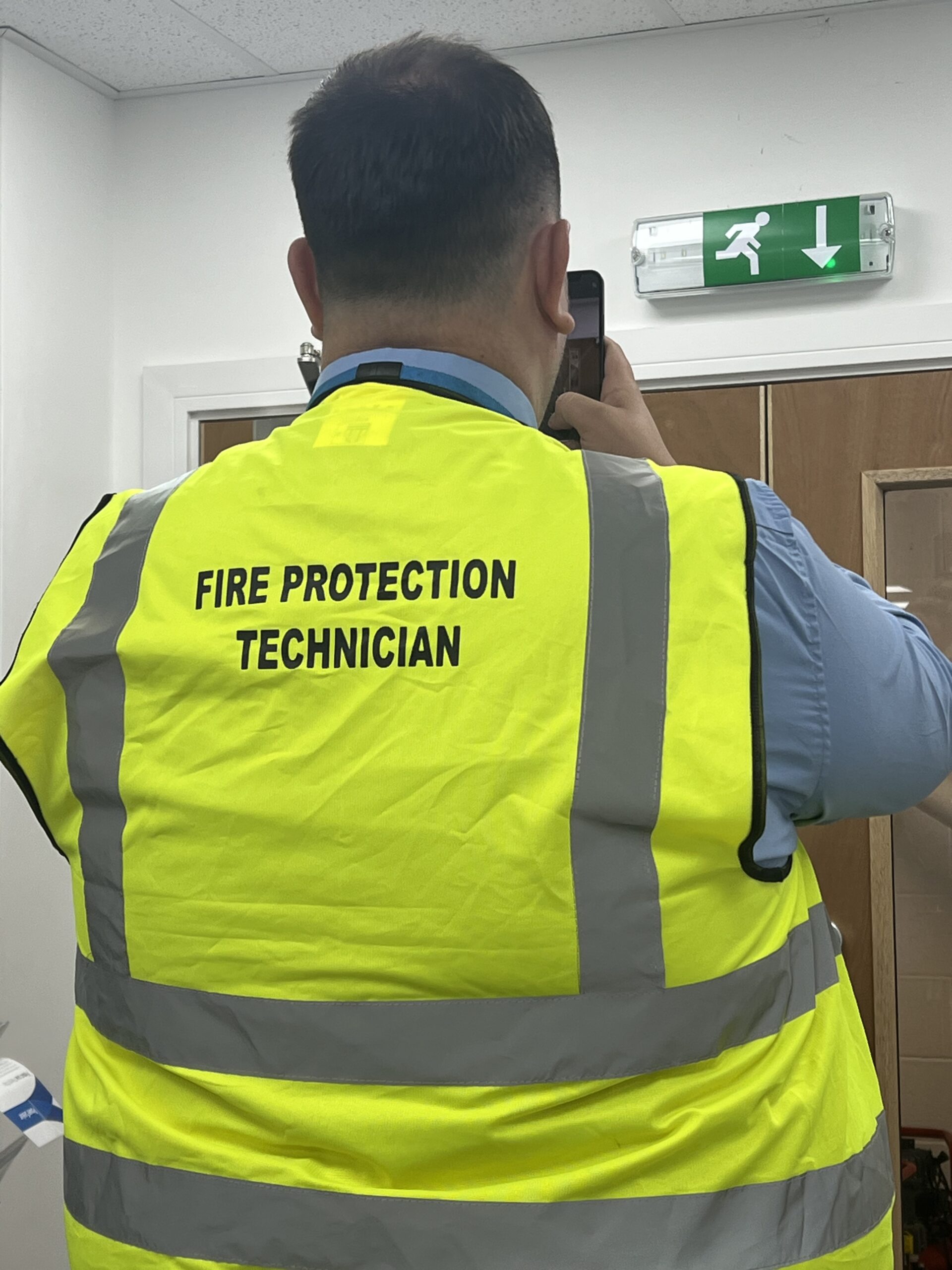 A fire risk assessor assessing a fire door using the BS 8674:2025 framework