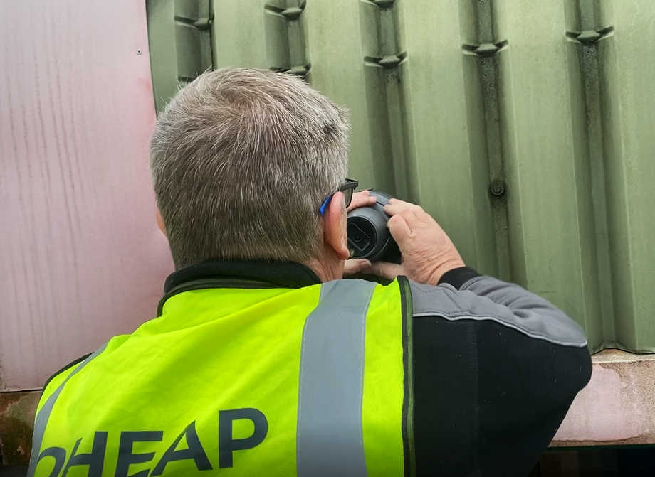 An engineer wearing a hi-vis jacket installing CCTV to the wall