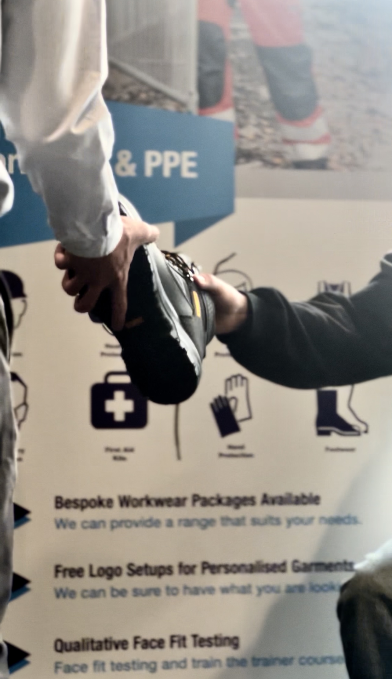 A safety work boot being handed to an engineer