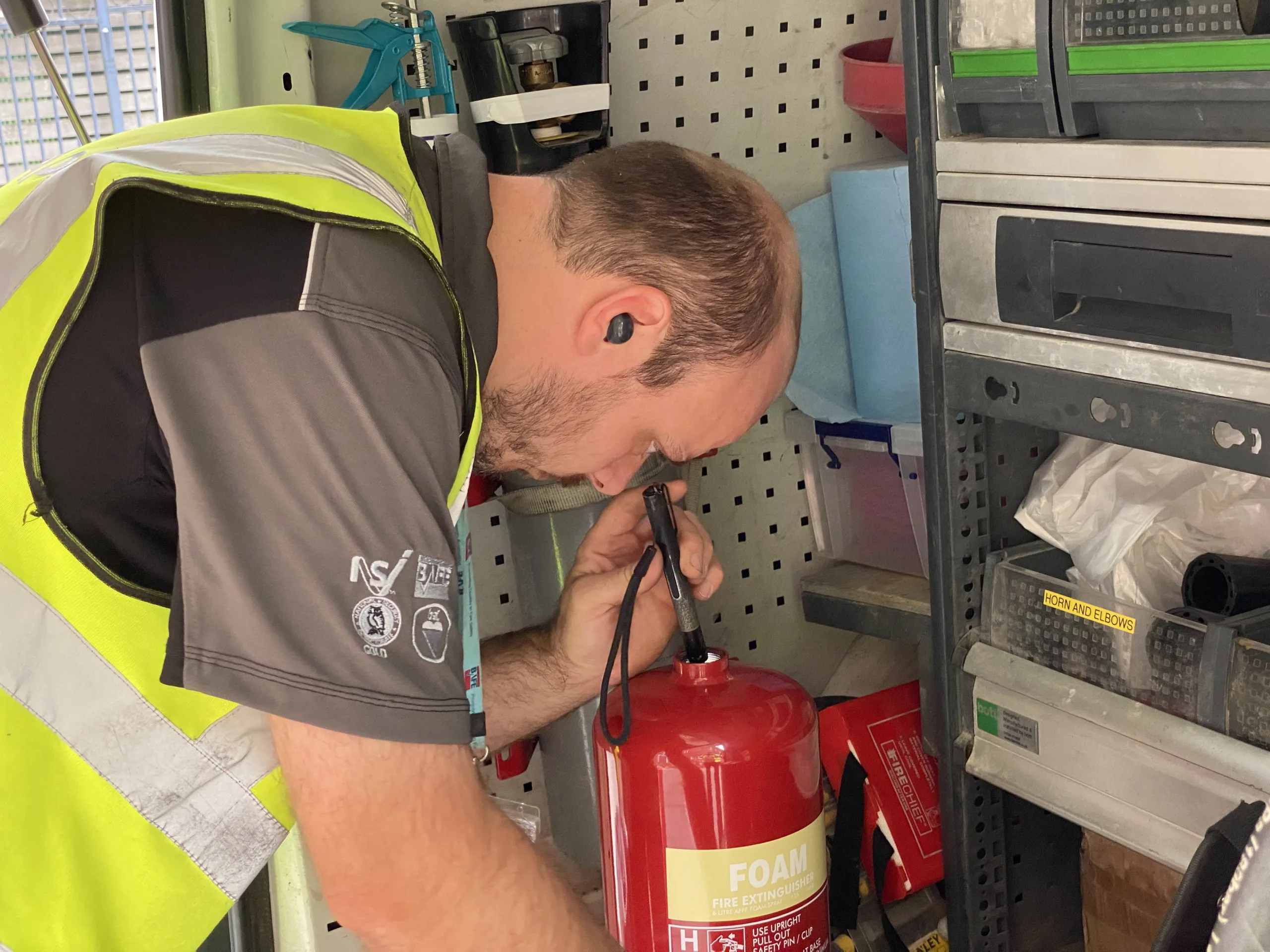 A BAFE accredited engineer checking the inside of an extinguisher for signs of rust