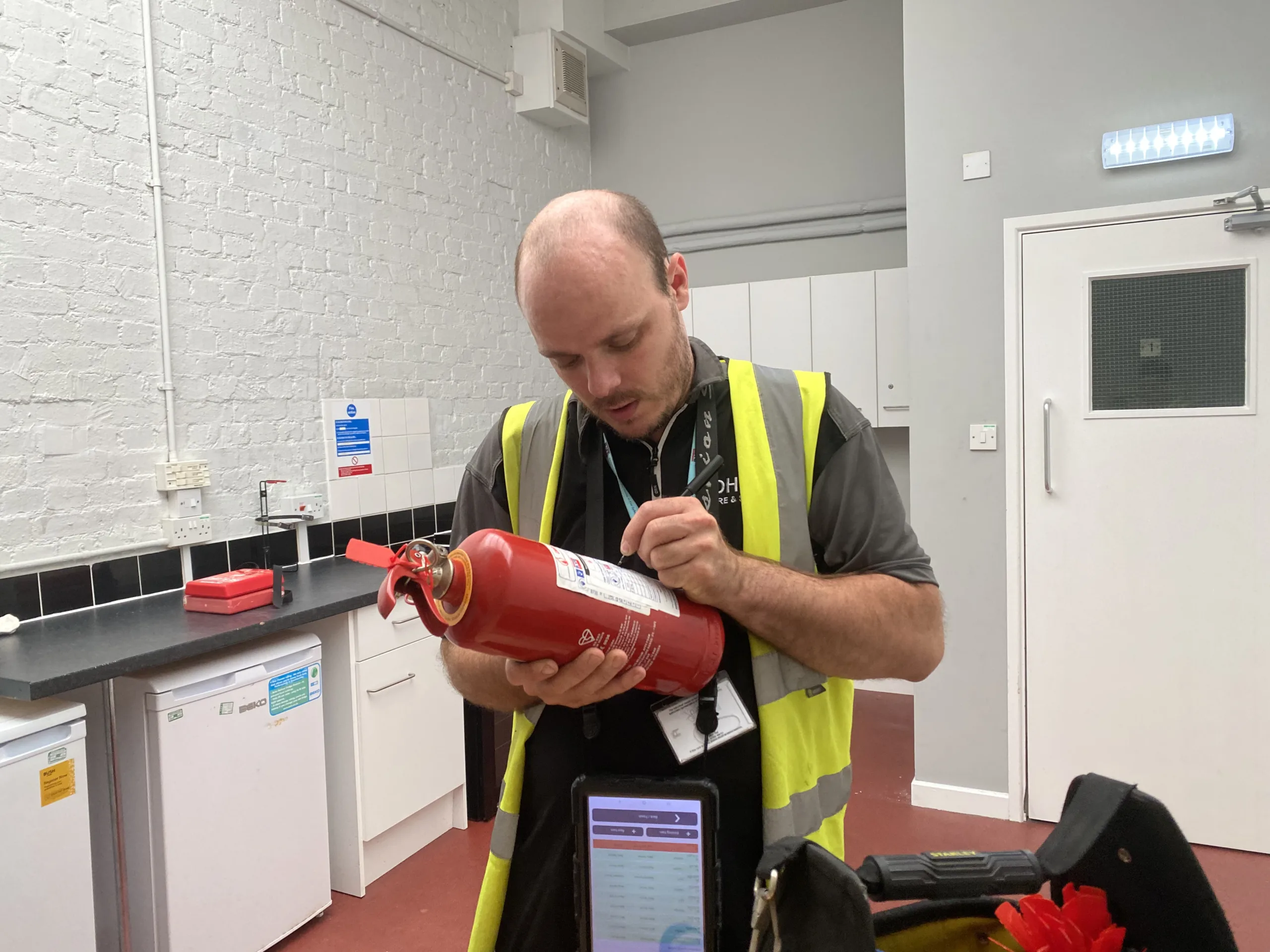 A certified engineer writing on the side of a pfas-free extinguisher 