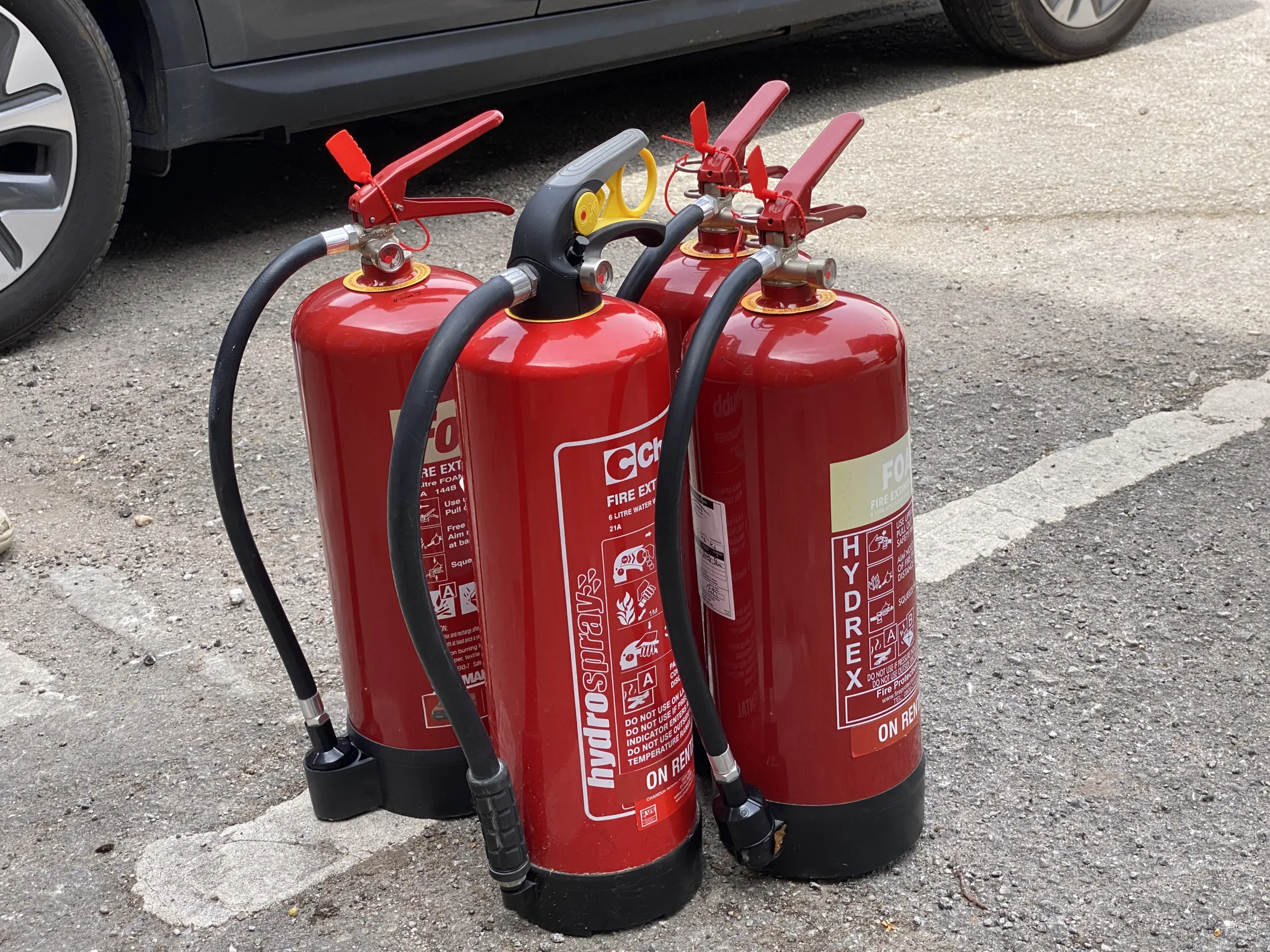 A row of fully serviced fire extinguishers complete with extinguisher tags and seals