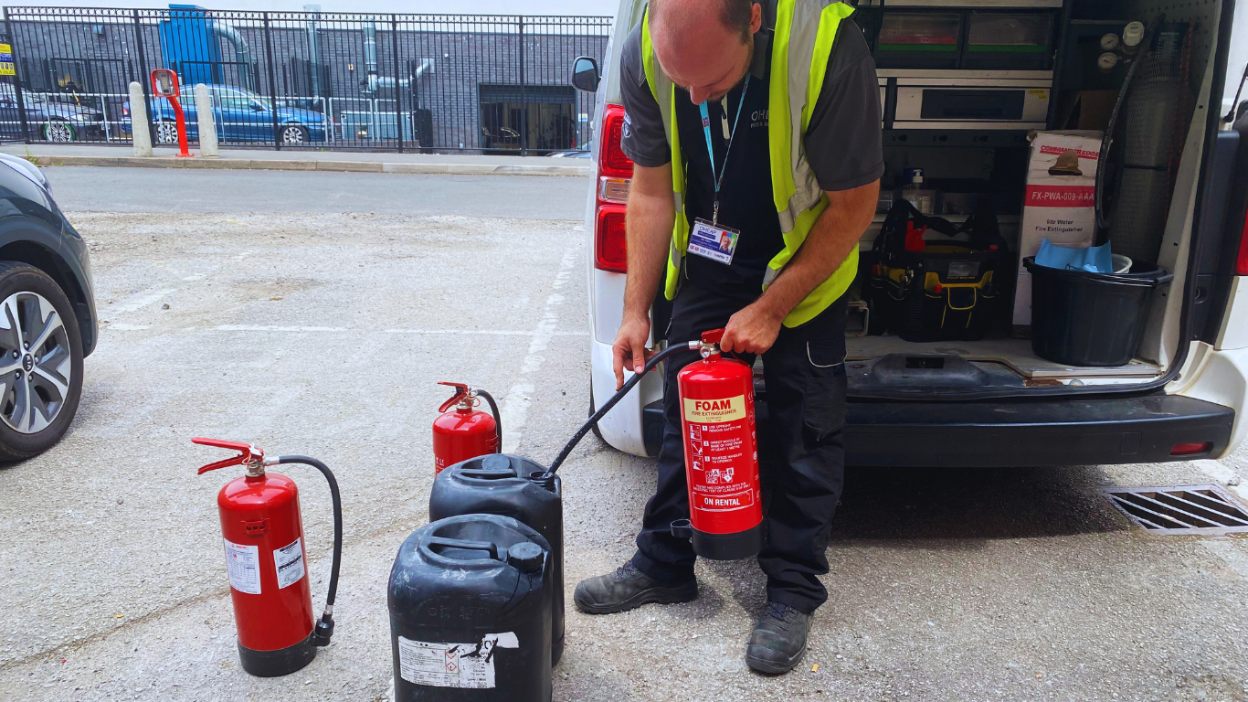 An OHEAP engineer discharge testing a PFAS-free foam fire extinguisher to replenish the extinguishing agent.