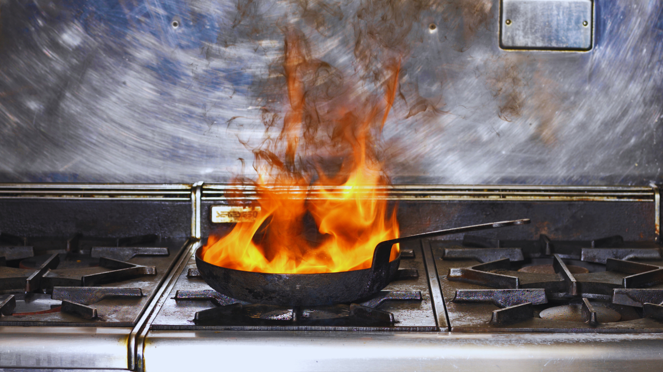 A kitchen fire burning in a frying pan