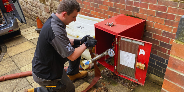 OHEAP Fire & Security engineer servicing a dry riser inlet