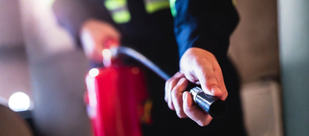 A fire warden holding the hose of a CO2 fire extinguisher