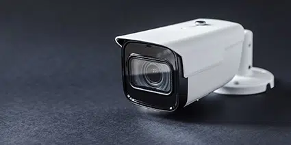 A bullet CCTV lying flat on a  reflective surface