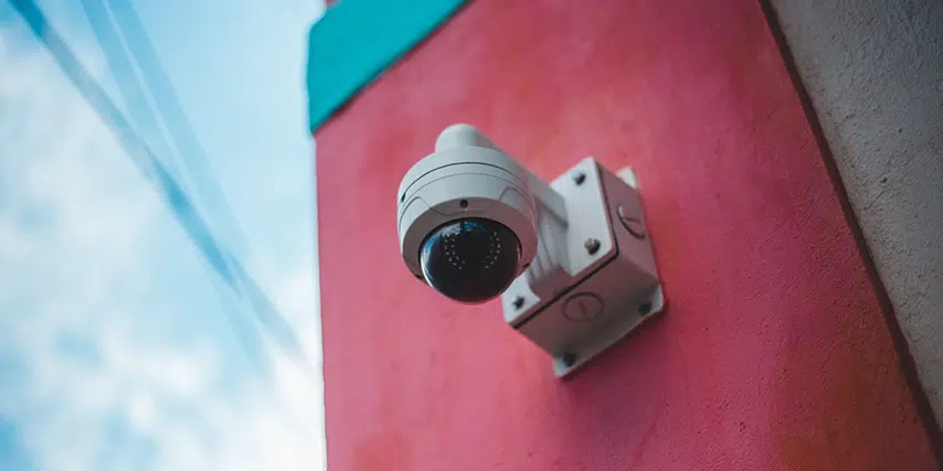A dome CCTV camera installed outside to a brightly coloured wall to demonstrate what is CCTV